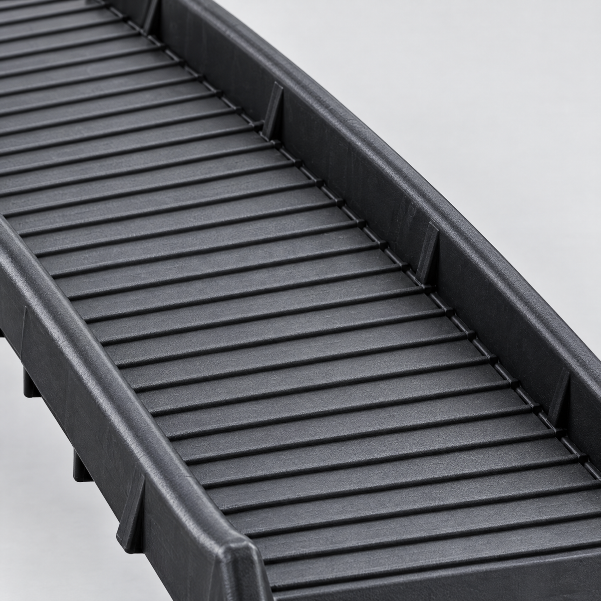 Detail der gerippten Lauffläche und erhöhten Seitenränder der Tatzenrampe™