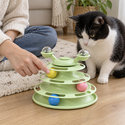 Eine Hand stößt eine Kugel an und lädt die Katze zum Mitspielen ein